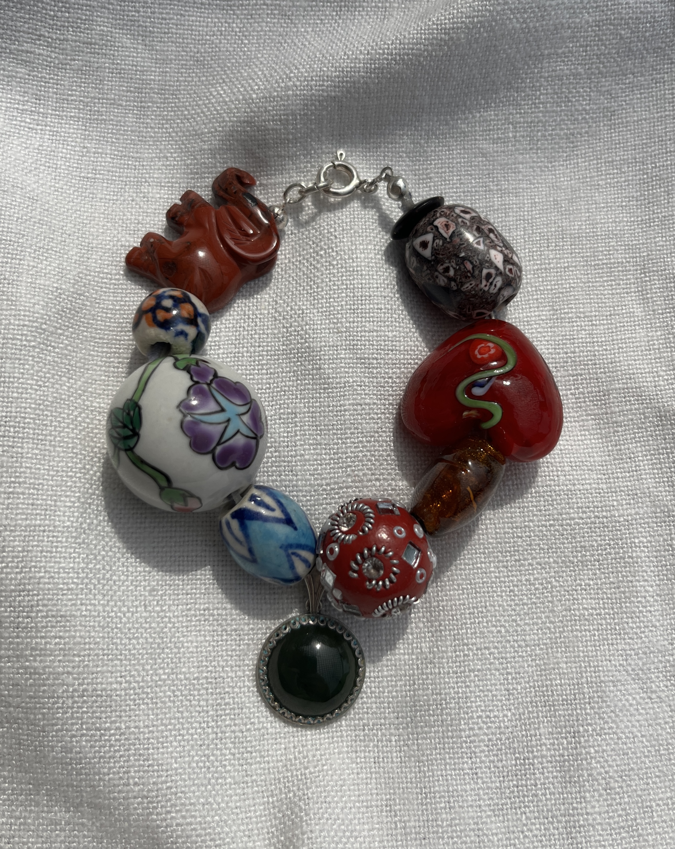 Muse handmade bracelet — painted ceramic, Murano glass, amber glass, carved stone and jade pendant, finished with silk ribbon
